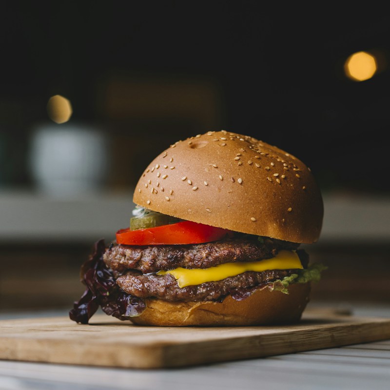 A double cheeseburger with melted cheese and a golden sesame bun